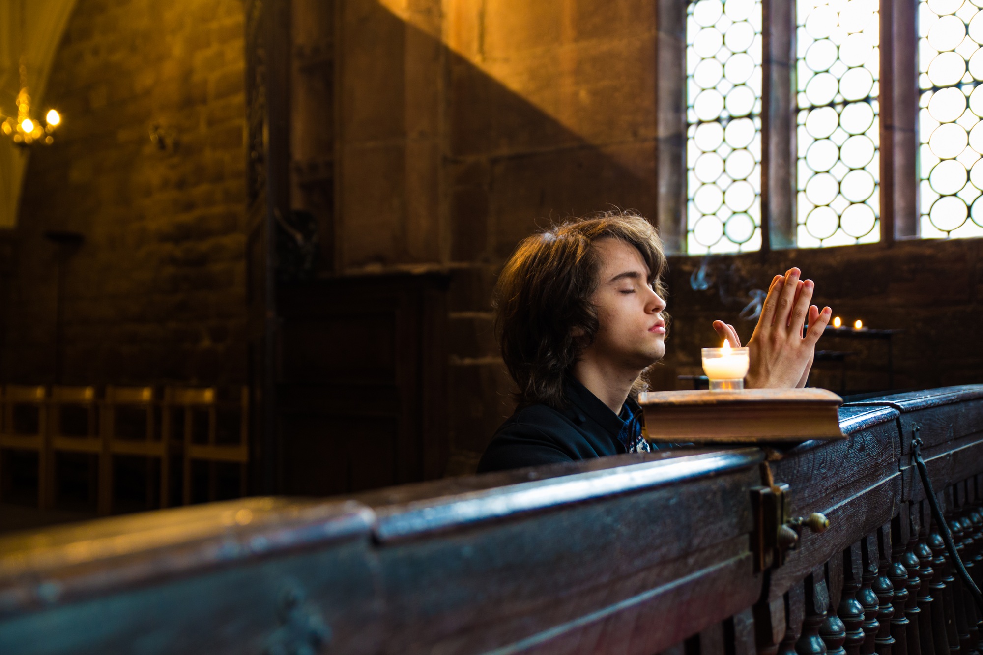 Young boy praying in a church